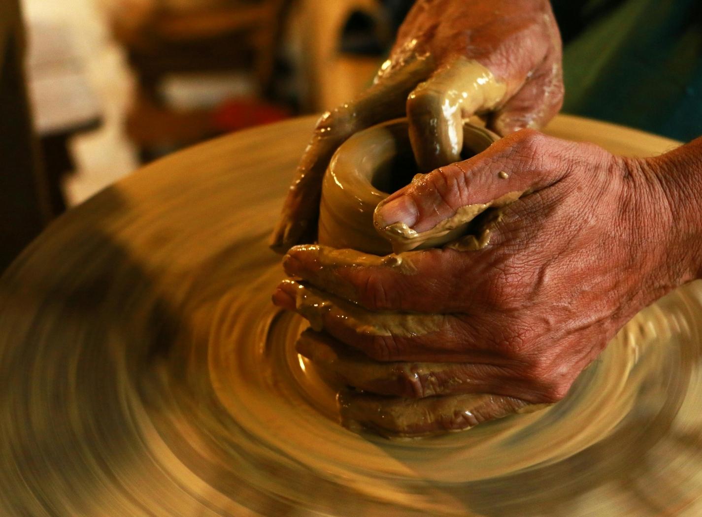 Mani che modellano l’argilla su una ruota da ceramista