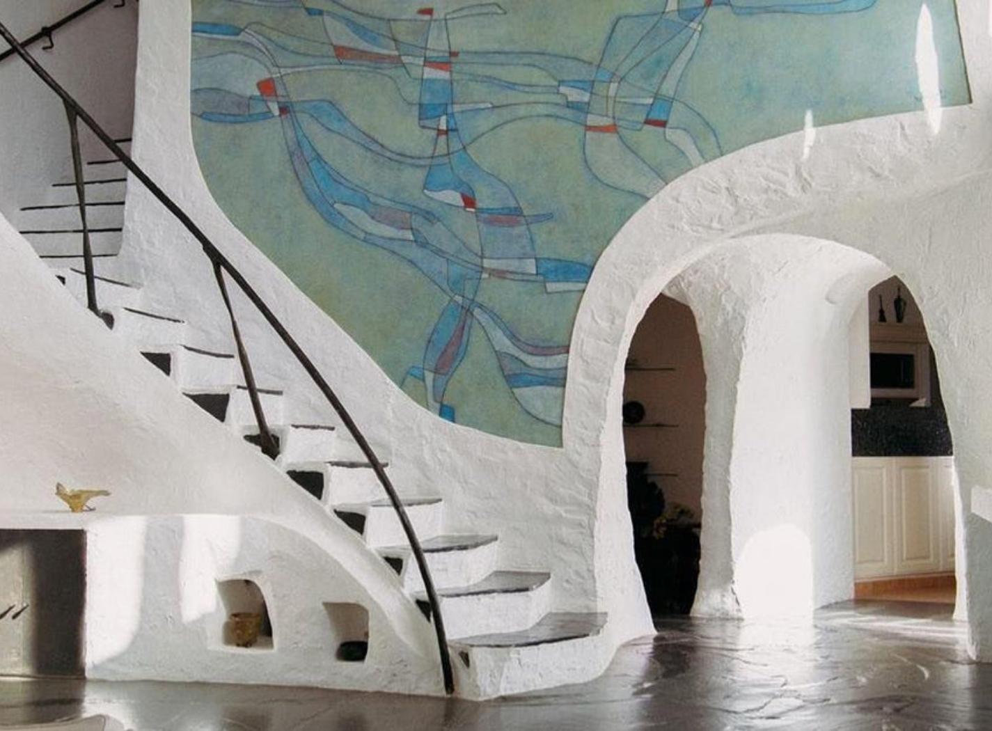 Interno di una casa-scultura di Jacques Couëlle, caratterizzato da superfici curve e continuità materica