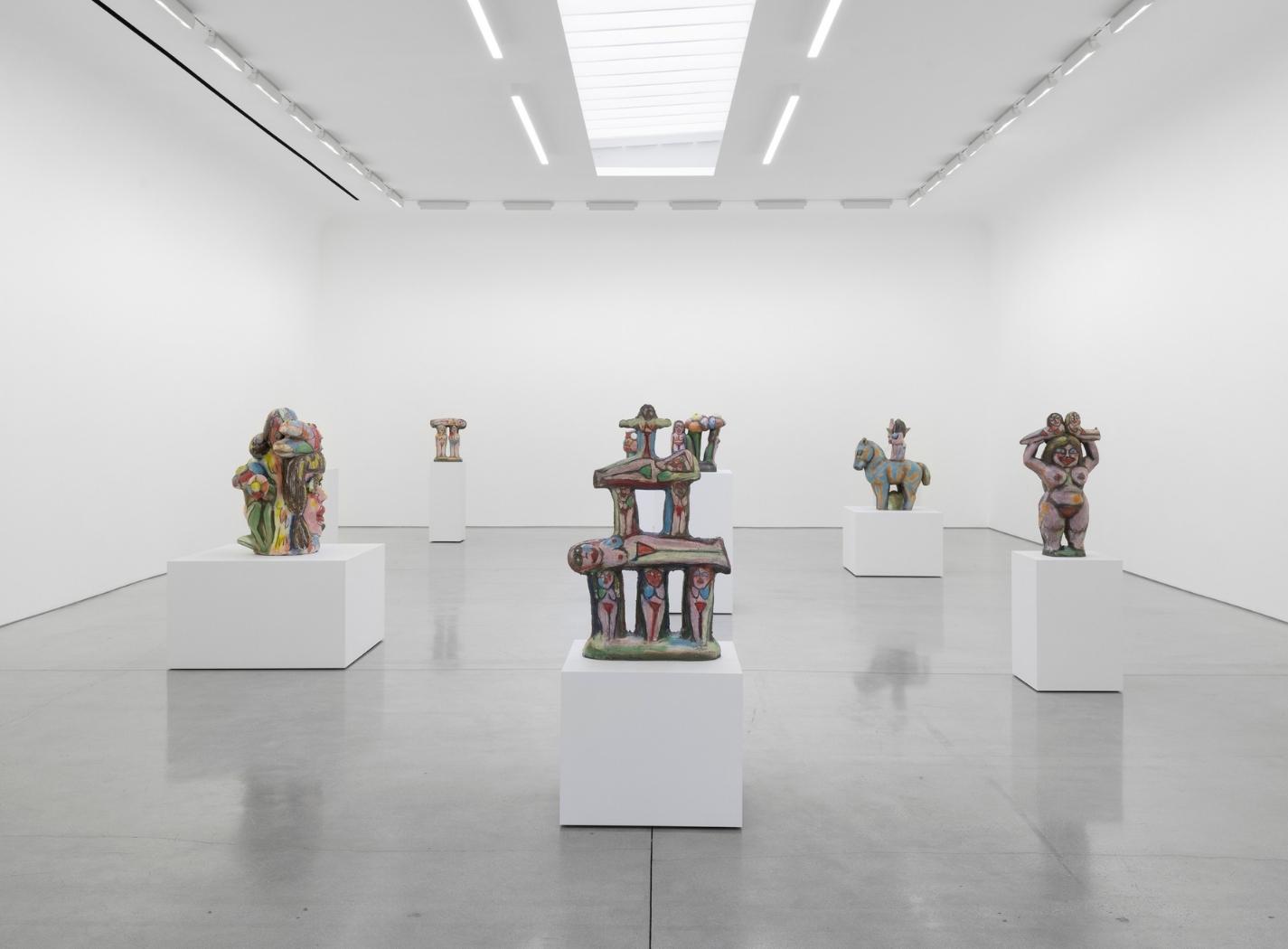 Installazione di sculture ceramiche figurative di Rubi Nery in uno spazio espositivo minimale