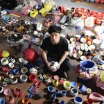 Takuro Kuwata nel suo studio circondato da opere ceramiche
